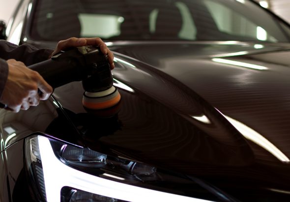 person polishing a black car
