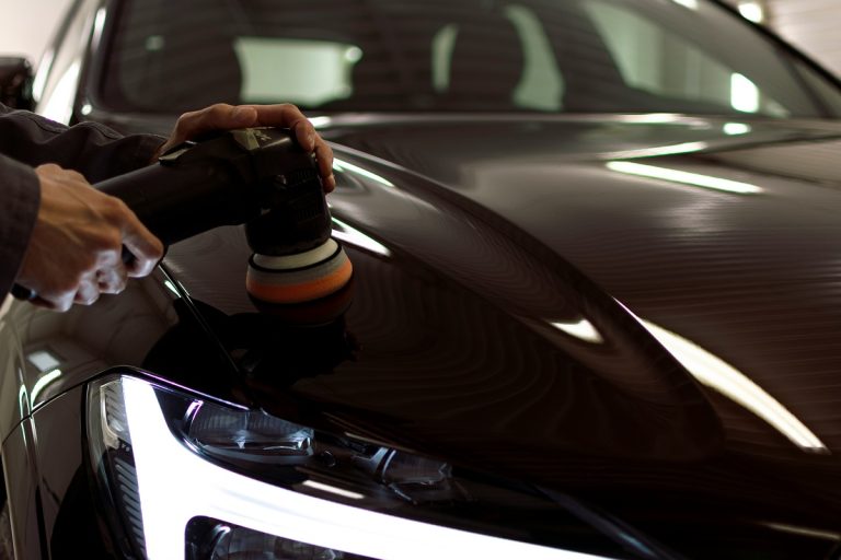person polishing a black car